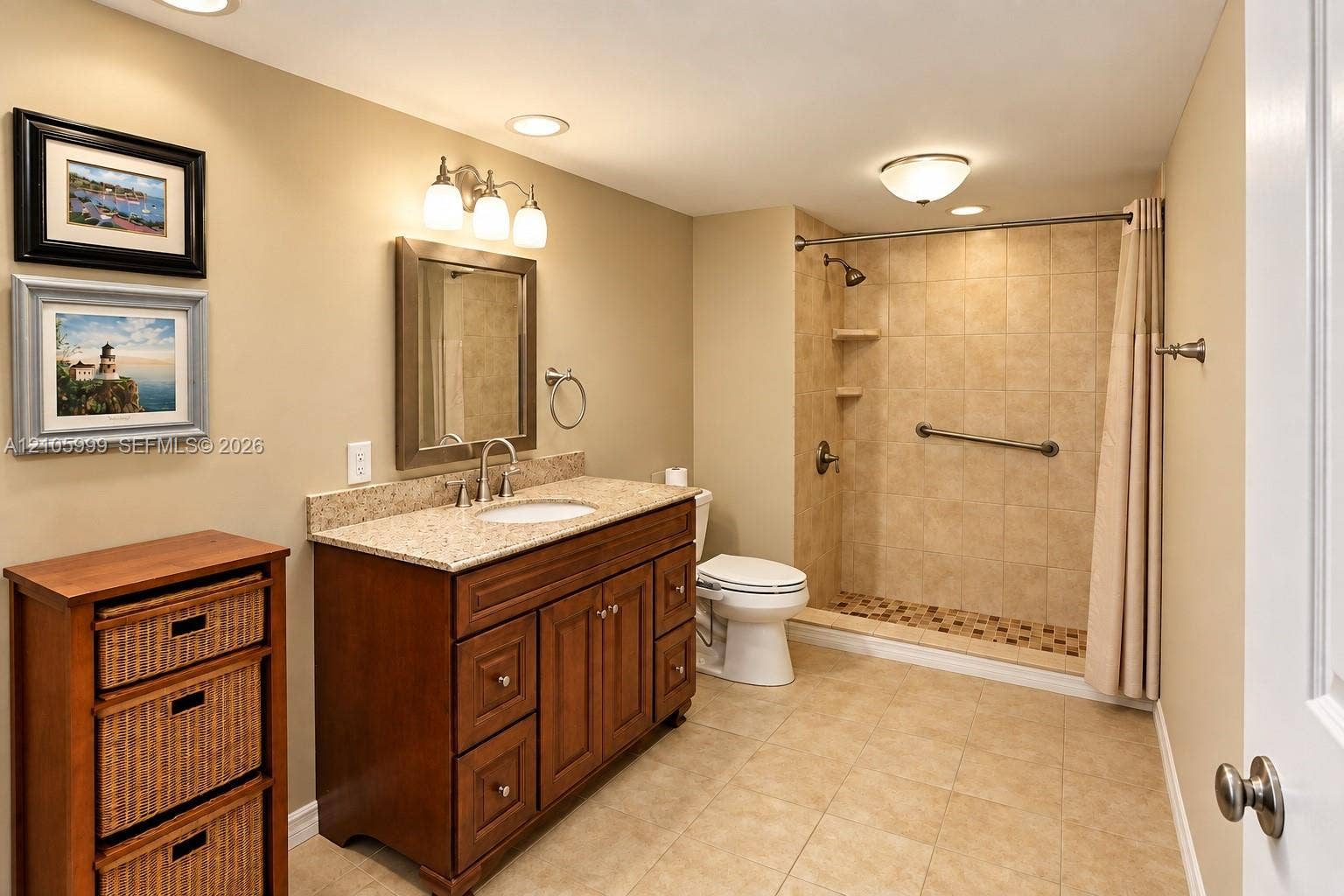 Bathroom featuring a wooden vanity with a stone countertop, an integrated sink, a walk-in shower with tiled walls, and recessed lighting