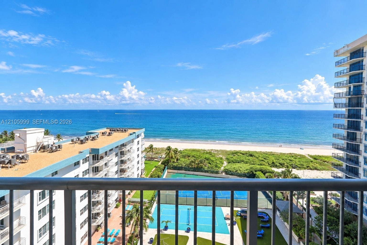 Oceanfront-Private balcony featuring metal railings with a direct perspective of the ocean, shoreline, and on-site tennis courts