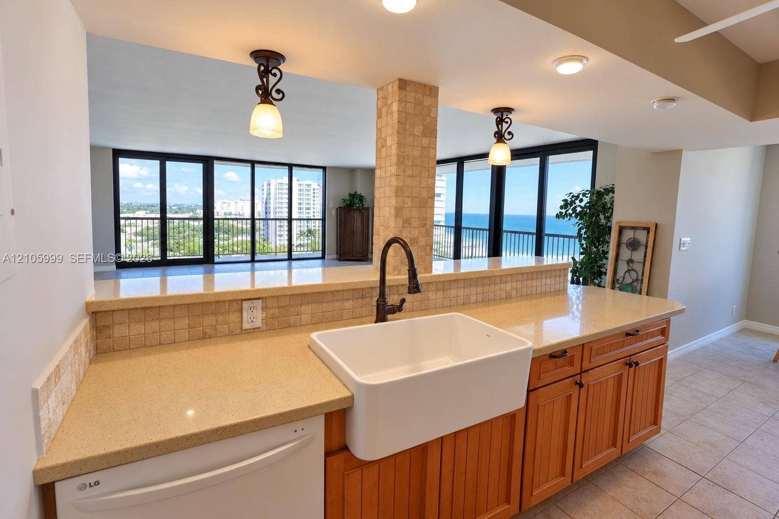 Kitchen featuring a farmhouse sink, stone countertops, tiled backsplash, wooden cabinetry, and pendant lighting