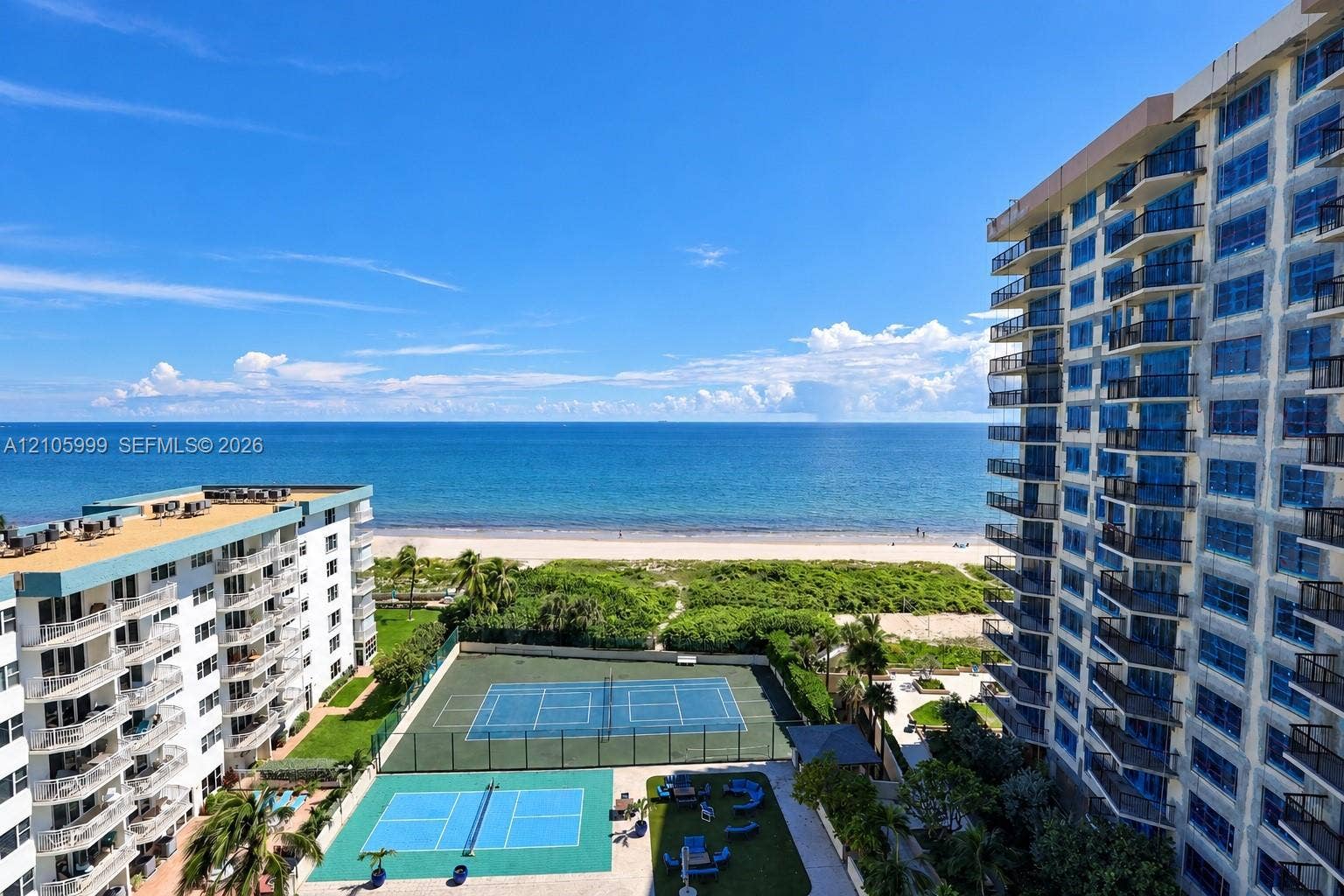 Oceanfront high-rise residence featuring direct beach access, two lighted tennis courts, manicured grounds with native landscaping, resort-style amenities, and unobstructed Atlantic views from elevated vantage point