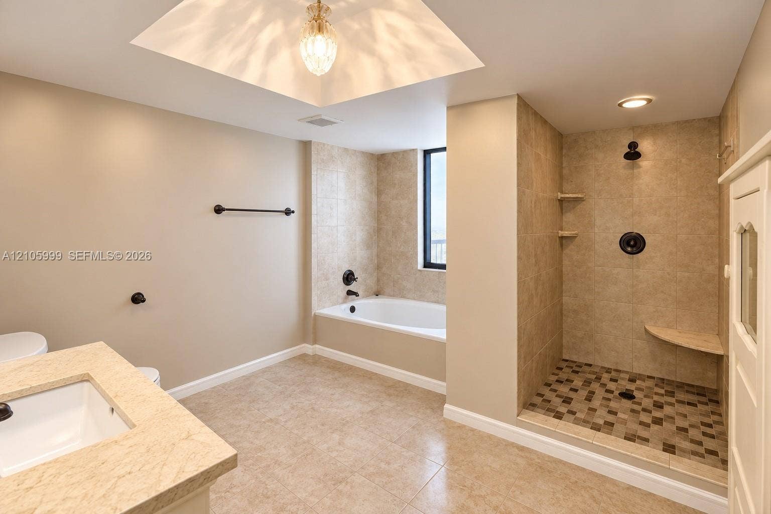 Bathroom featuring a walk-in shower with mosaic tile flooring, built-in corner bench, soaking tub, stone-surfaced vanity, and recessed ceiling lighting