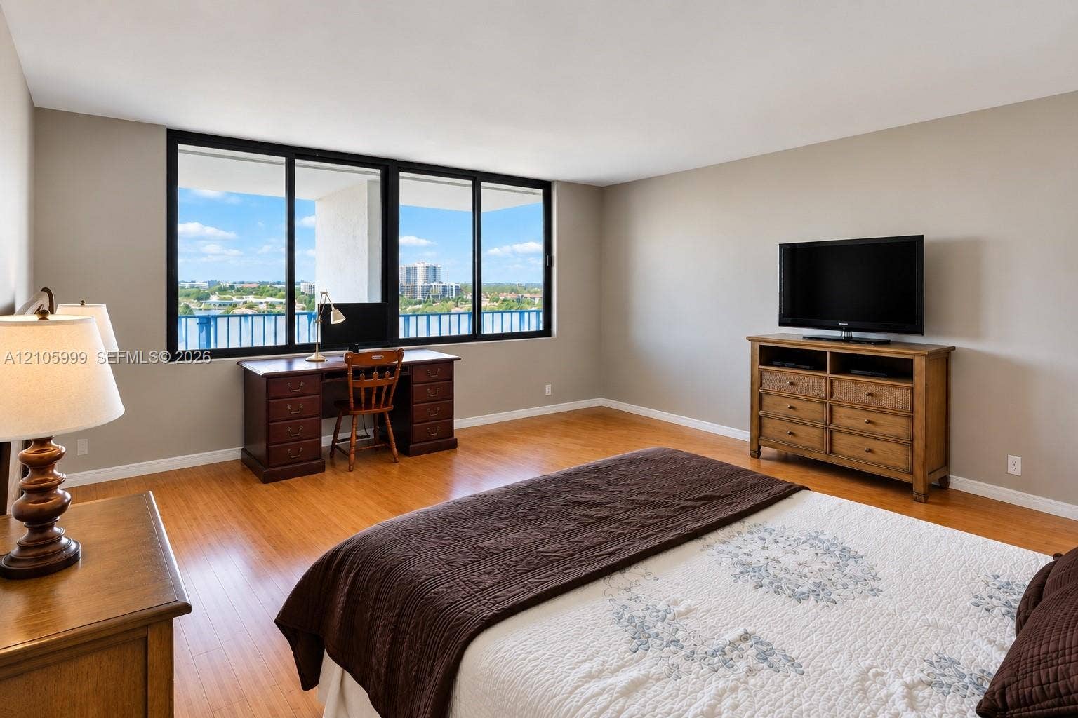 Large floor-to-ceiling windows, wood-finish flooring, and expansive outdoor terrace access