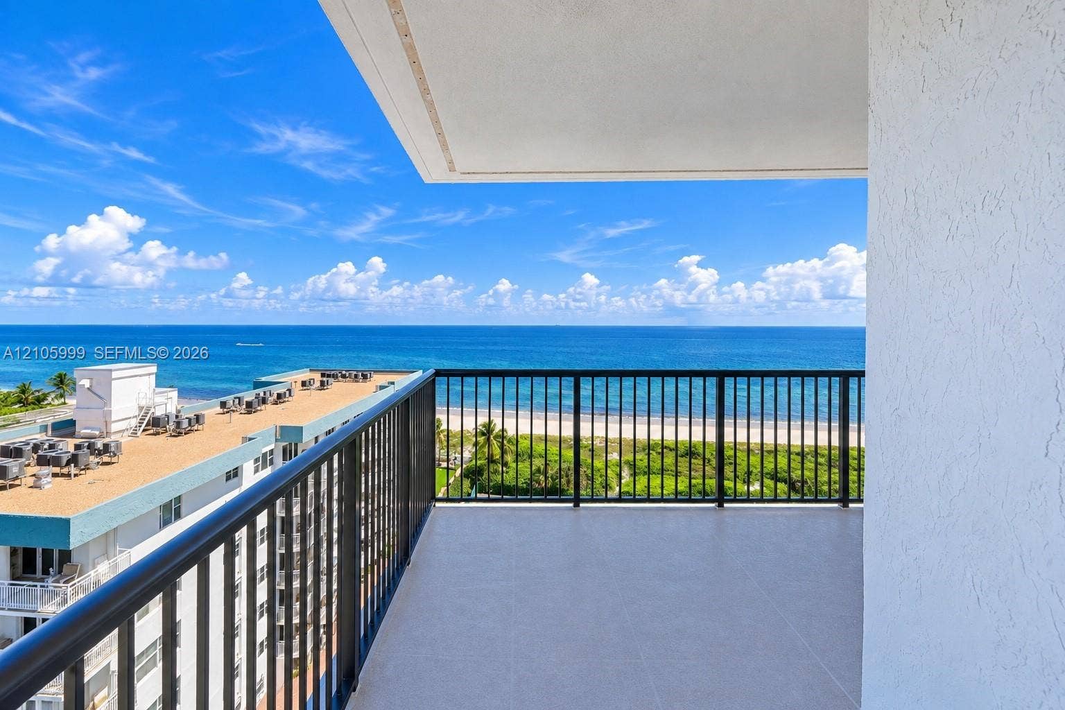 Private balcony featuring tile flooring and black metal railings with an expanse of ocean scenery
