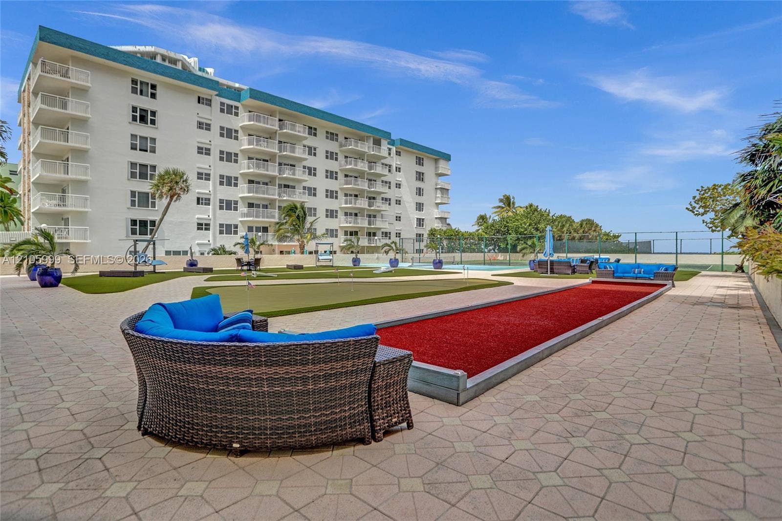 Exterior recreation area featuring a paved terrace, putting green, and bocce ball court