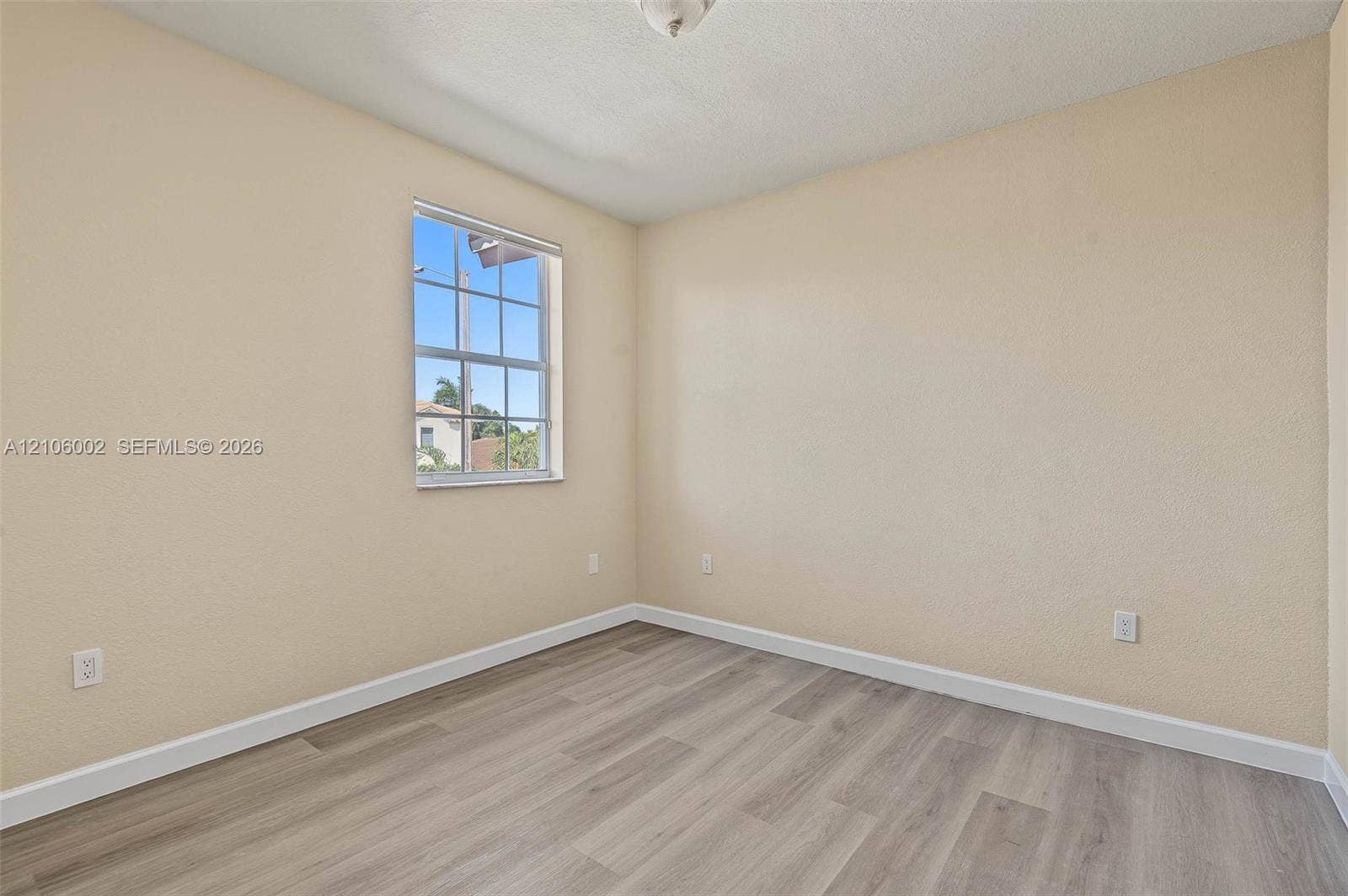 Neutral wall finishes, wood-finish flooring, and a single-hung grid window