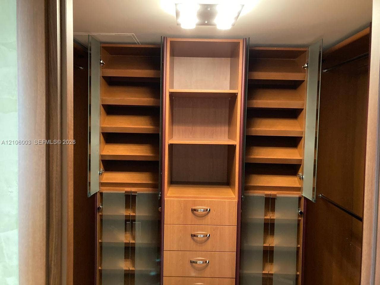 1850 S Ocean Drive, #3309, Hallandale Beach, Hallandale Beach, FL 33009 Custom built-in wood-finish closet storage system featuring adjustable shelving, integrated drawers with metallic pulls, frosted glass cabinet doors, and recessed ceiling lighting