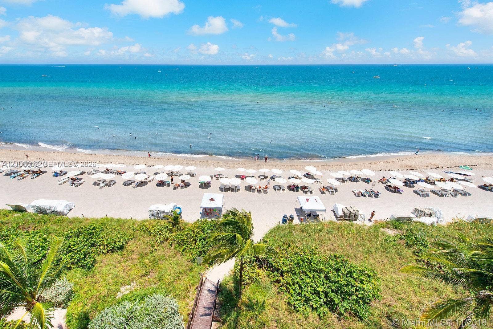 1850 S Ocean Drive, #3309, Hallandale Beach, Hallandale Beach, FL 33009 Direct oceanfront property featuring sandy beach access, a wooden boardwalk, manicured dune vegetation, and palm trees