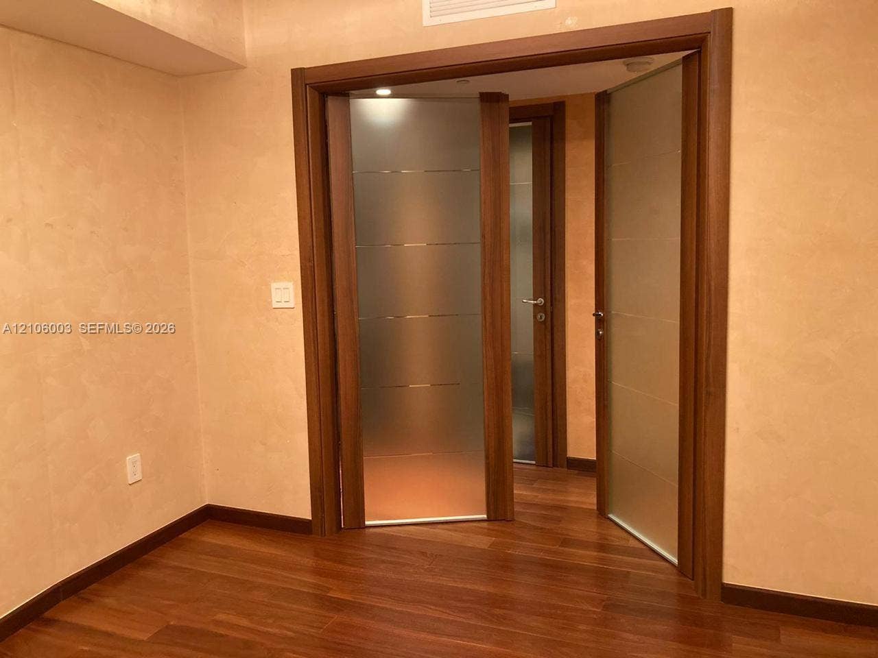 1850 S Ocean Drive, #3309, Hallandale Beach, Hallandale Beach, FL 33009 Wood-finish flooring, textured wall finish, and wood-framed doors with frosted glass inserts and horizontal metal accents