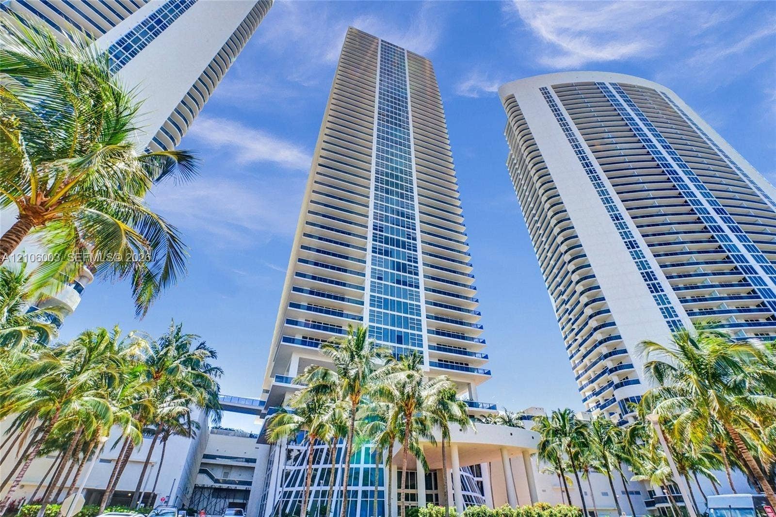 1850 S Ocean Drive, #3309, Hallandale Beach, Hallandale Beach, FL 33009 High-rise glass and concrete residential towers featuring floor-to-ceiling windows, wrap-around balconies, and palm-lined exterior landscaping