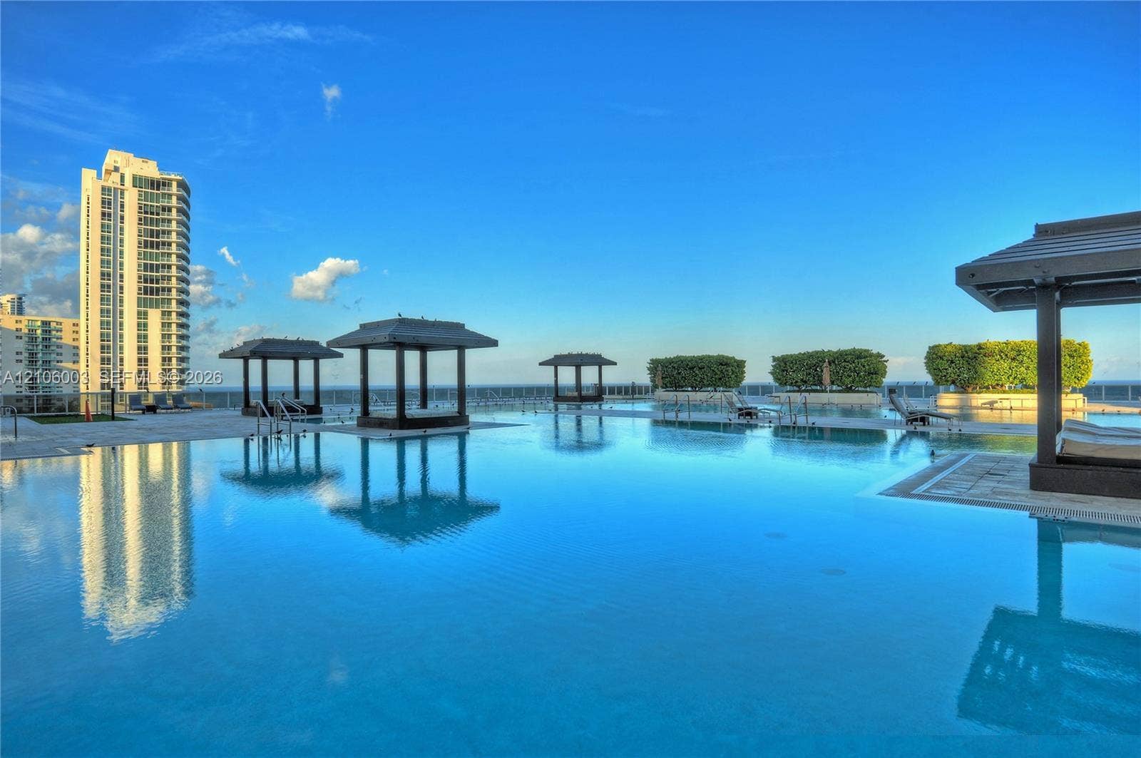 1850 S Ocean Drive, #3309, Hallandale Beach, Hallandale Beach, FL 33009 Rooftop infinity-edge pool featuring multiple built-in cabanas, stone pool decking, and integrated landscaping planters