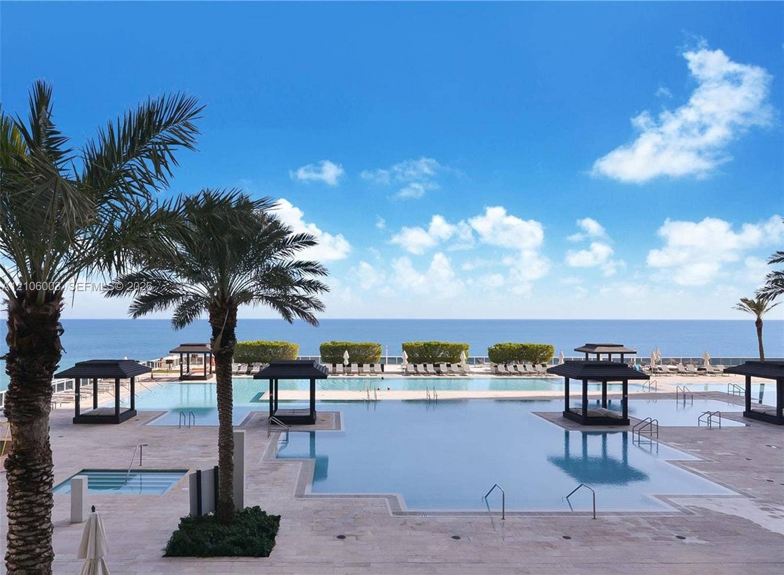 1850 S Ocean Drive, #3309, Hallandale Beach, Hallandale Beach, FL 33009 Expansive resort-style swimming pool featuring multiple built-in cabanas, stone-finish decking, and an ocean backdrop