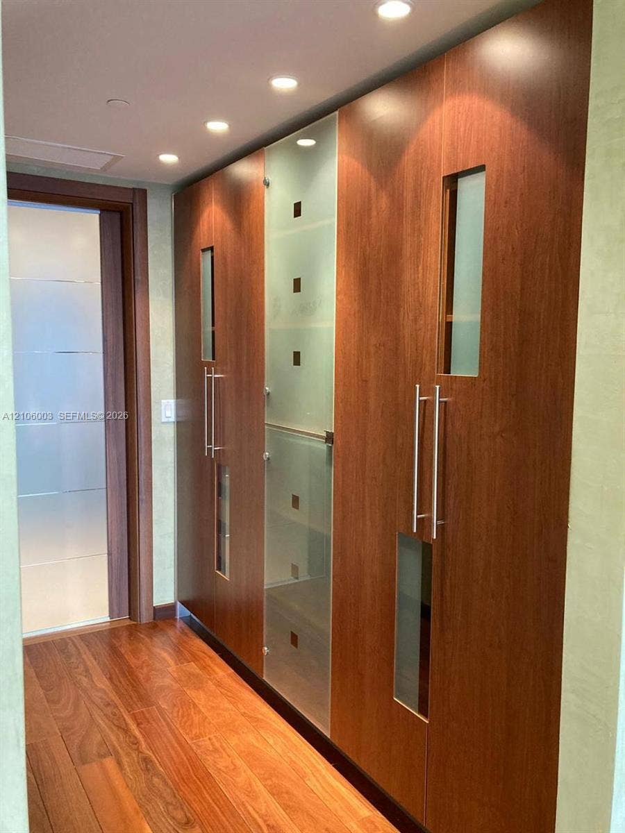 1850 S Ocean Drive, #3309, Hallandale Beach, Hallandale Beach, FL 33009 Floor-to-ceiling cabinetry featuring wood-finish panels, frosted glass inserts, brushed metal hardware, and recessed ceiling lighting