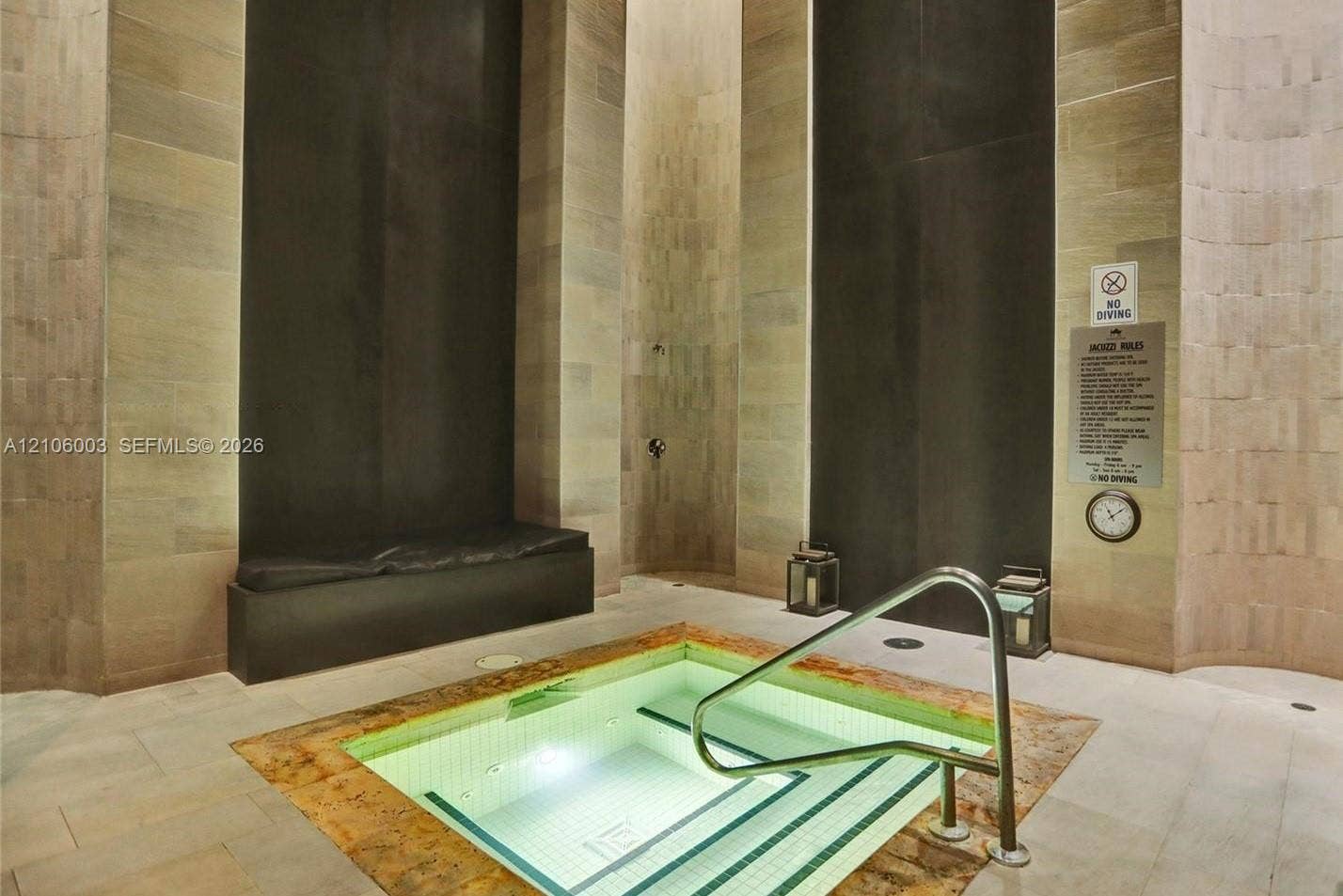 1850 S Ocean Drive, #3309, Hallandale Beach, Hallandale Beach, FL 33009 Indoor hydrotherapy pool featuring stone tile flooring, vertical stone wall accents, integrated bench seating, and a metal handrail