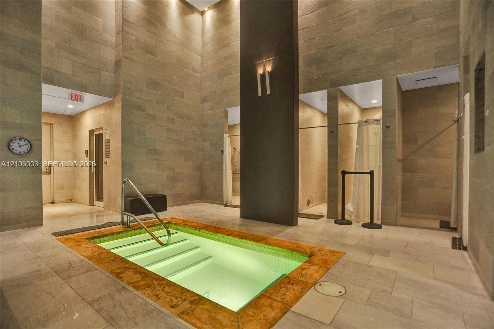 1850 S Ocean Drive, #3309, Hallandale Beach, Hallandale Beach, FL 33009 Indoor spa area featuring a tiled plunge pool with metal handrail, full-height stone wall cladding, multiple private shower enclosures, and recessed ceiling lighting