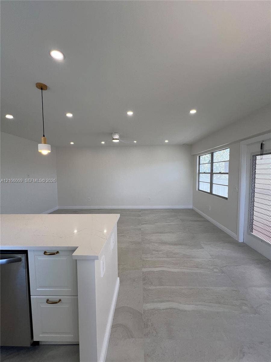 495 Fanshaw L, Boca Raton, FL 33434 Kitchen island with stone-finish countertop, large-format tile flooring, recessed ceiling lighting, pendant lighting, and neutral wall tones