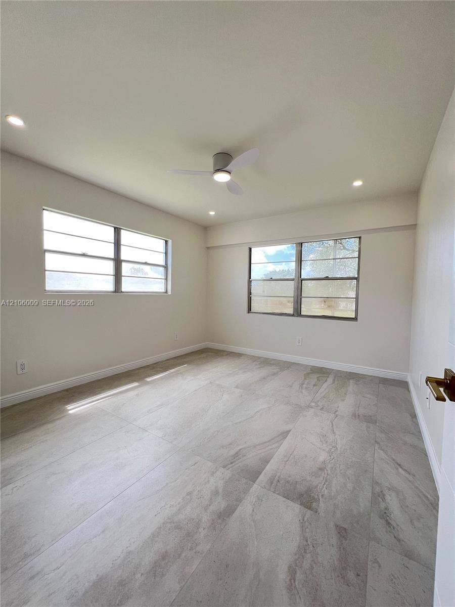 495 Fanshaw L, Boca Raton, FL 33434 Neutral-toned room featuring large-format tile flooring, recessed lighting, and a modern ceiling fan with an integrated light fixture