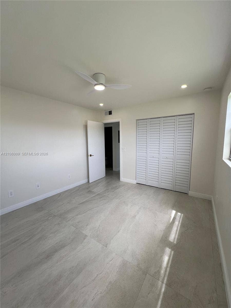 495 Fanshaw L, Boca Raton, FL 33434 Large-format tile flooring, modern flush-mount ceiling fan, recessed lighting, and bifold louvered closet doors