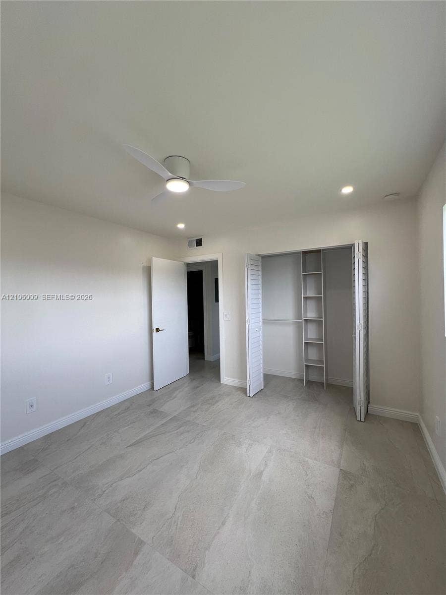 495 Fanshaw L, Boca Raton, FL 33434 Interior space featuring large-format tile flooring, recessed lighting, a modern ceiling fan, and a closet with integrated built-in shelving