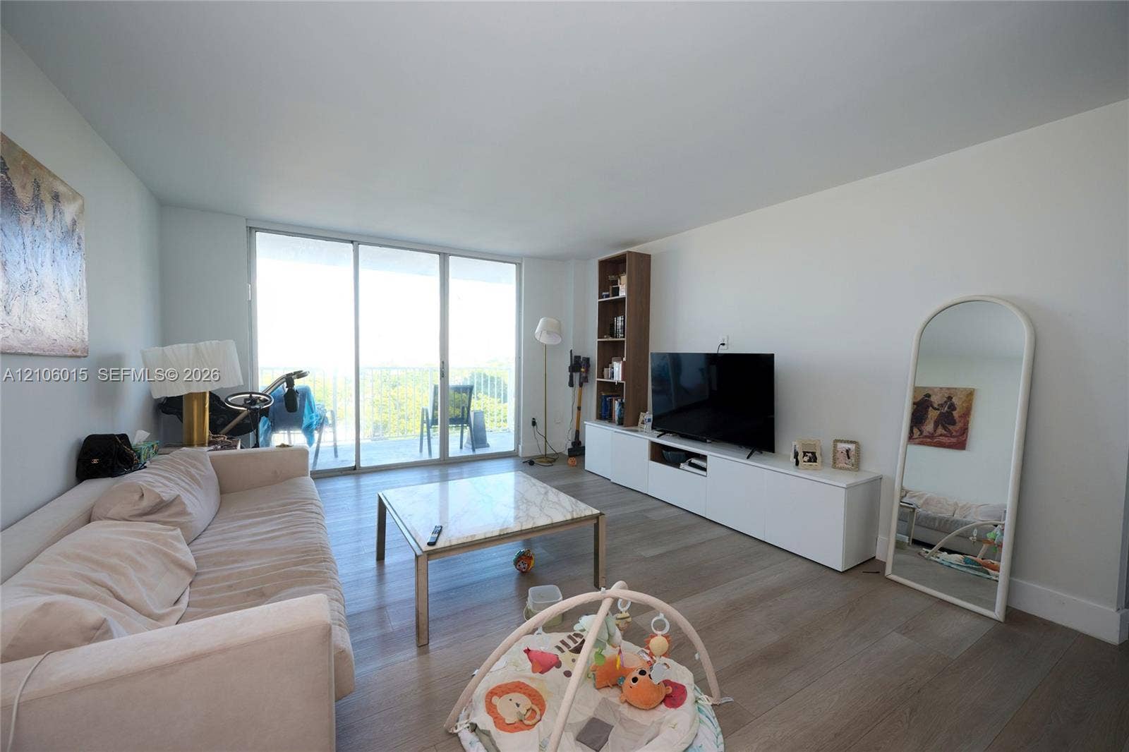 2851 NE 183rd Street, #1109E, Aventura, FL 33160 Living area featuring wood-finish flooring, floor-to-ceiling sliding glass doors, and white built-in cabinetry