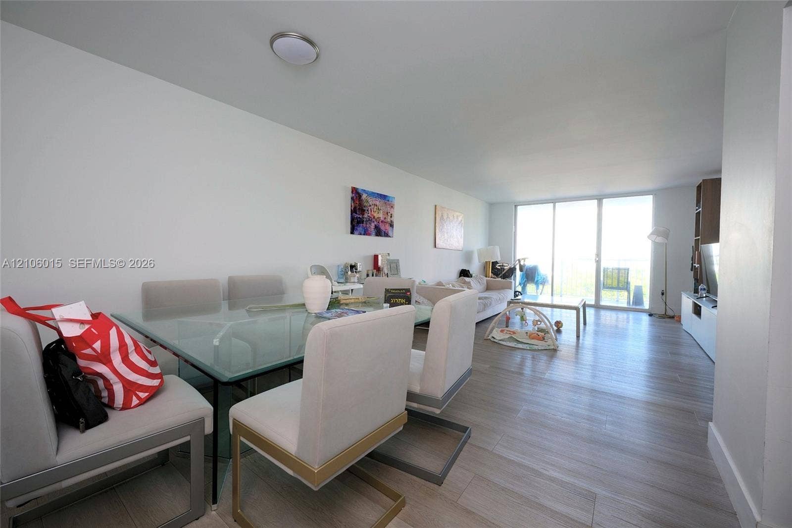 2851 NE 183rd Street, #1109E, Aventura, FL 33160 Open-concept interior featuring light wood-finish flooring and large floor-to-ceiling glass doors