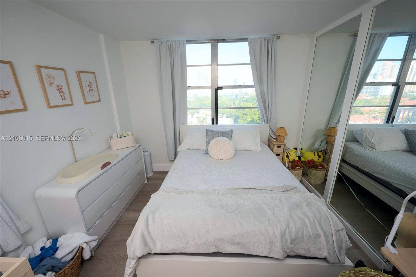 2851 NE 183rd Street, #1109E, Aventura, FL 33160 Bedroom featuring wood-finish flooring, large floor-to-ceiling windows, and wall-to-wall mirrored closet doors