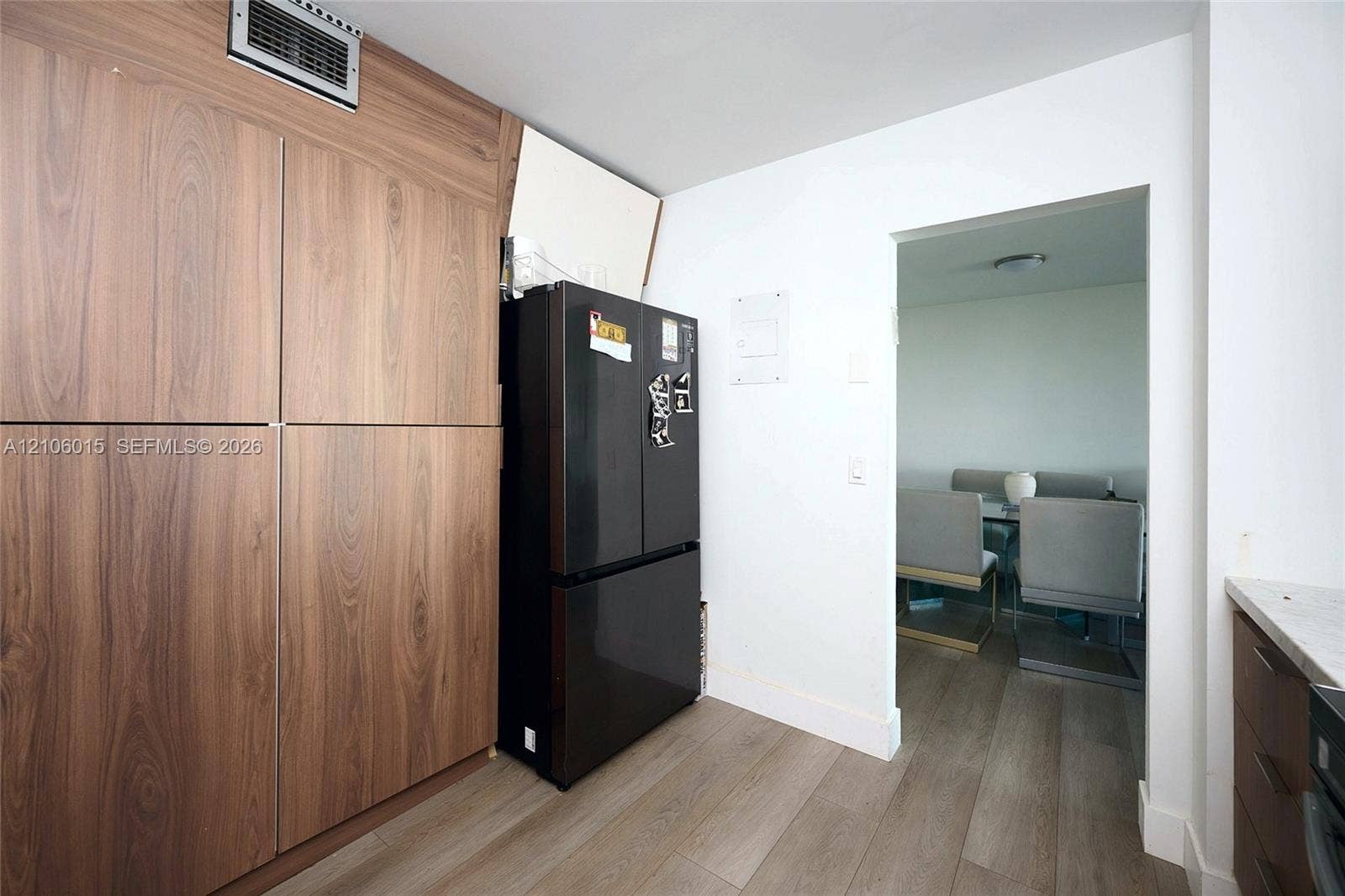 2851 NE 183rd Street, #1109E, Aventura, FL 33160 Floor-to-ceiling wood-finish cabinetry, built-in black refrigerator, and wood-finish flooring