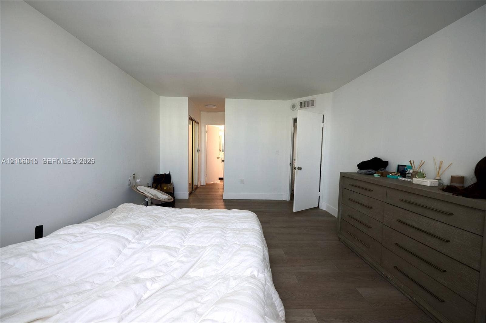 2851 NE 183rd Street, #1109E, Aventura, FL 33160 Neutral-toned wood-finish flooring, white walls, and closet with mirrored sliding doors