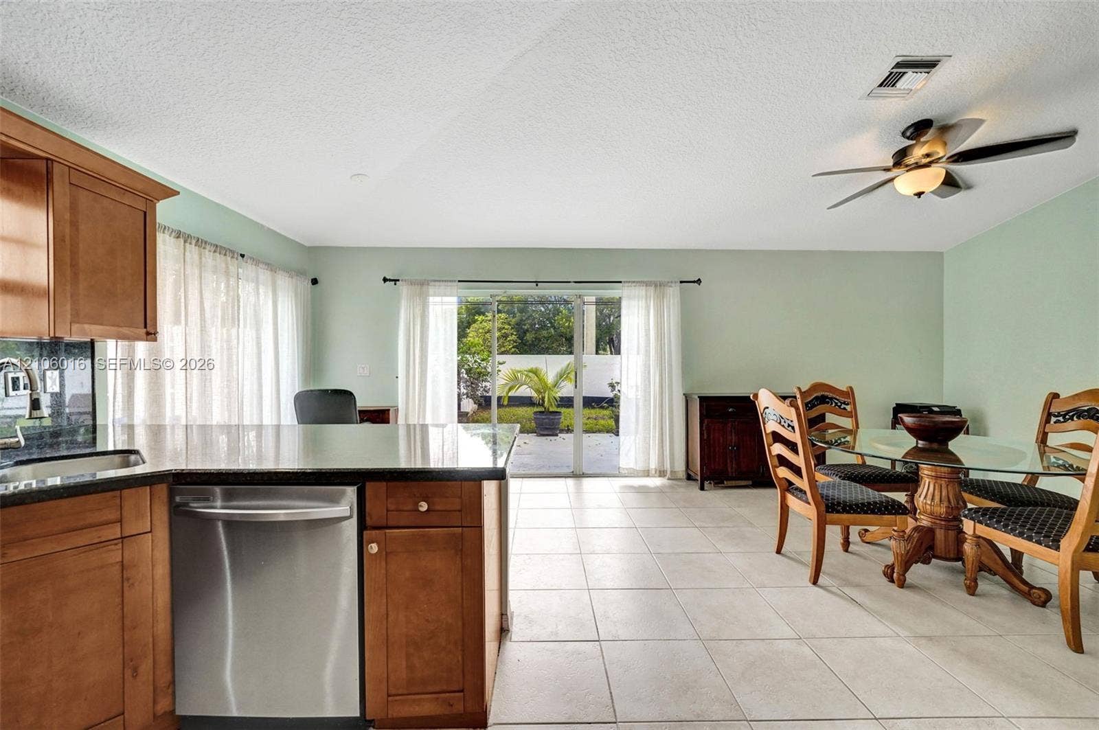 631 NW 135th Terrace, Plantation, FL 33325 Kitchen featuring light wood-finish cabinetry, solid-surface countertops, stainless steel dishwasher, tile flooring, and a ceiling fan