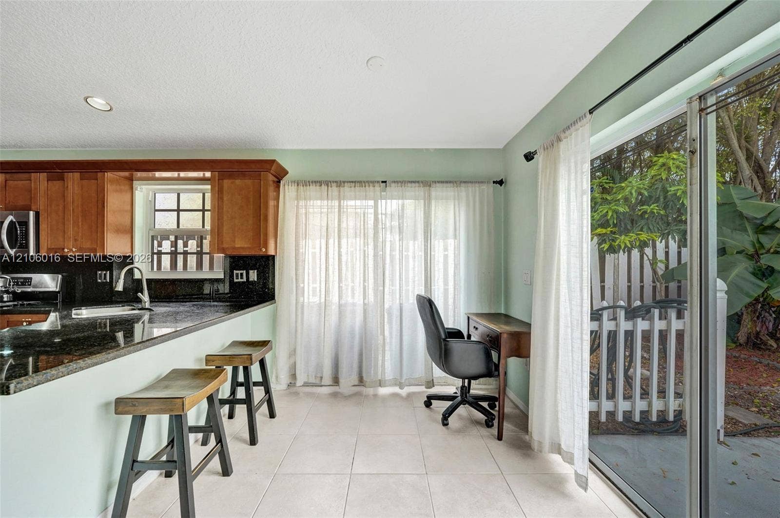 631 NW 135th Terrace, Plantation, FL 33325 Kitchen featuring wood cabinetry, stone countertops, recessed lighting, tile flooring, and sliding glass doors