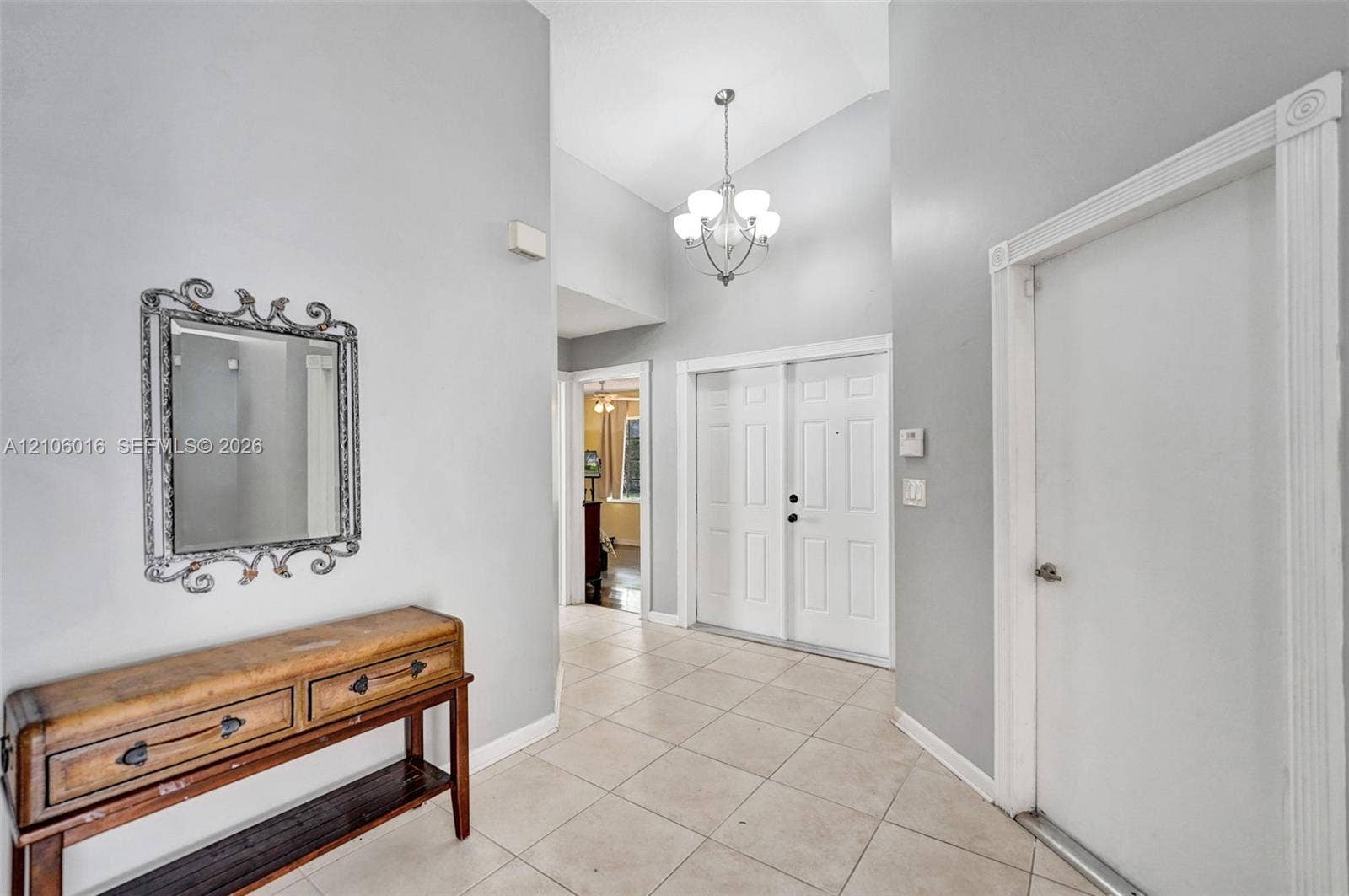 631 NW 135th Terrace, Plantation, FL 33325 Foyer featuring vaulted ceilings, neutral ceramic tile flooring, double-door entry, and a multi-light chandelier