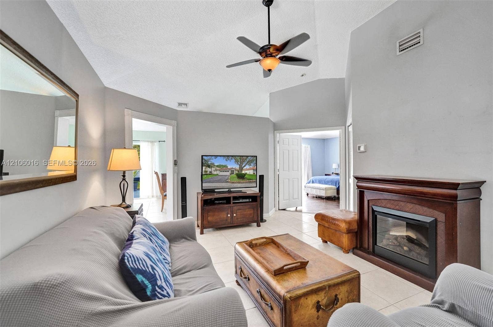 631 NW 135th Terrace, Plantation, FL 33325 Vaulted ceilings, tiled flooring, and a fireplace with a dark wood-finish mantel