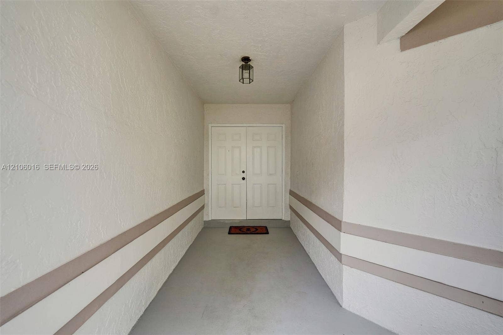 631 NW 135th Terrace, Plantation, FL 33325 Covered entryway featuring double entry doors, textured wall finishes, and overhead lantern-style lighting
