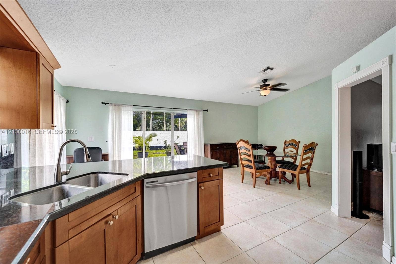 631 NW 135th Terrace, Plantation, FL 33325 Kitchen featuring wood cabinetry, stone-finish countertops, an undermount stainless steel sink, and a stainless steel dishwasher, with ceramic tile flooring throughout
