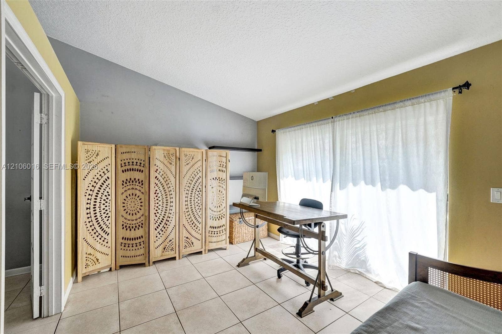 631 NW 135th Terrace, Plantation, FL 33325 Room featuring a vaulted ceiling, neutral tile flooring, and large sliding glass doors