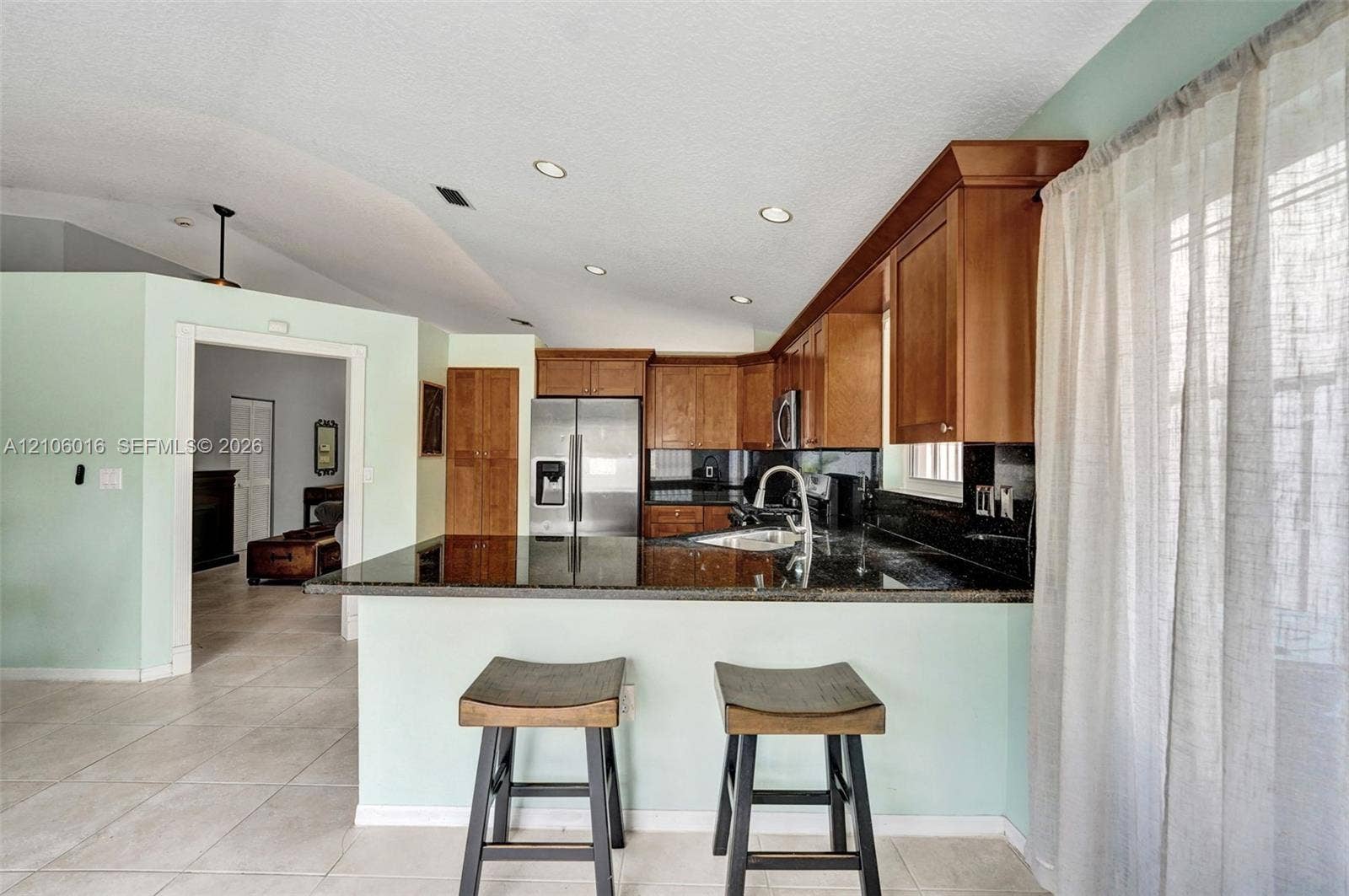 631 NW 135th Terrace, Plantation, FL 33325 Kitchen featuring wood cabinetry, stone-surface countertops, tile flooring, stainless steel refrigerator, and recessed lighting