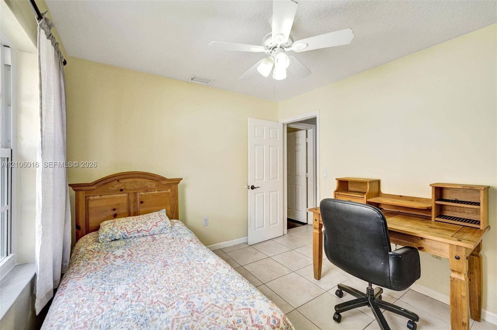 631 NW 135th Terrace, Plantation, FL 33325 Neutral-toned interior featuring tile flooring, a multi-blade ceiling fan with integrated lighting, and a six-panel interior door
