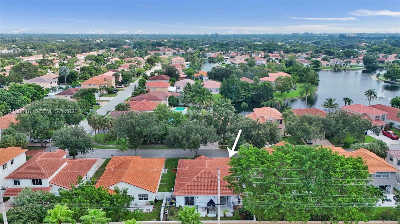 631 NW 135th Terrace, Plantation, FL 33325 Aerial perspective of a single-story residence featuring a terracotta tile roof and mature tree canopy situated within a neighborhood setting