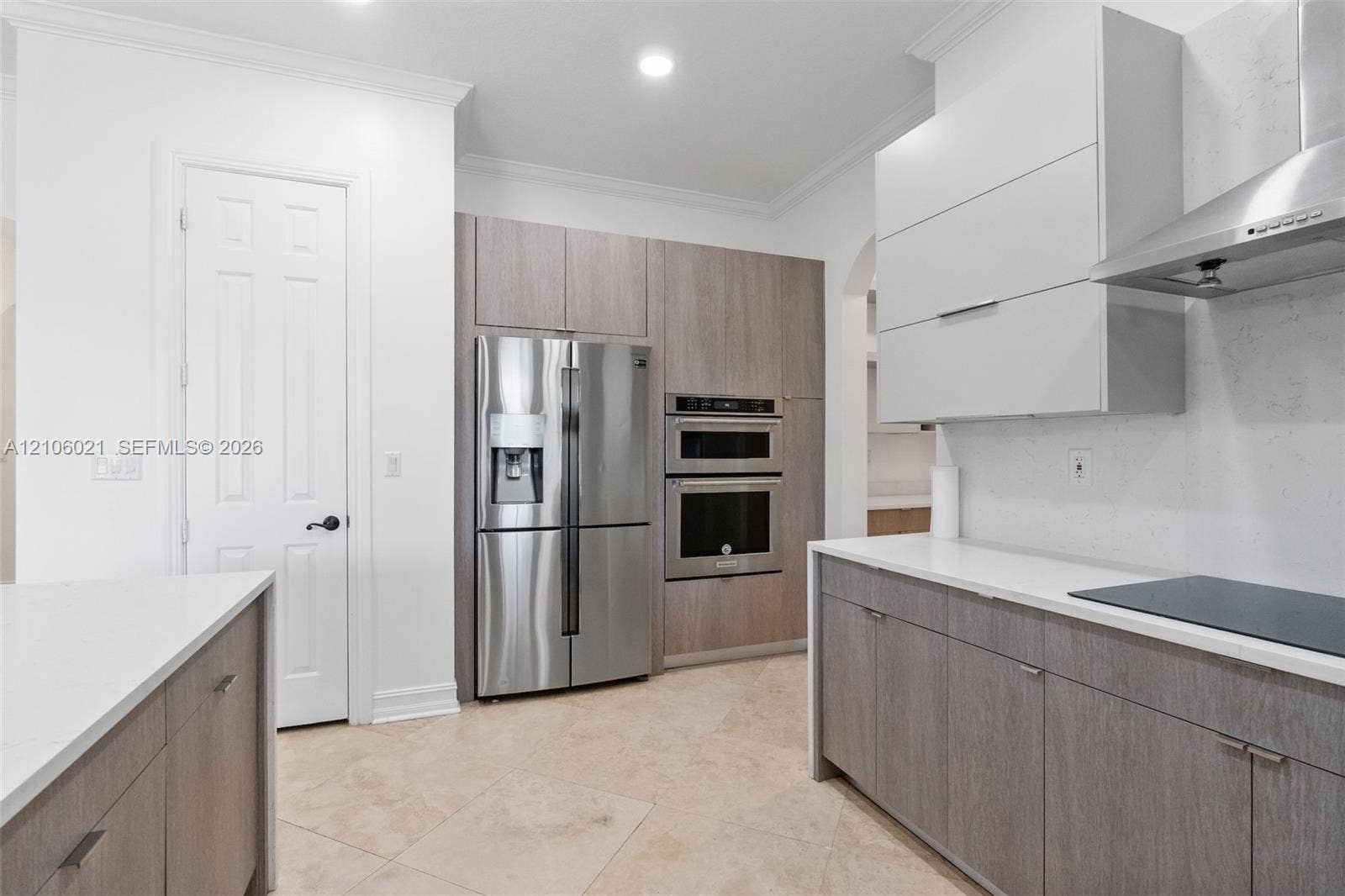 19510 S Coquina Way, Weston, FL 33332 Kitchen featuring two-tone cabinetry, quartz countertops, tile flooring, stainless steel built-in double ovens, and a stainless steel range hood