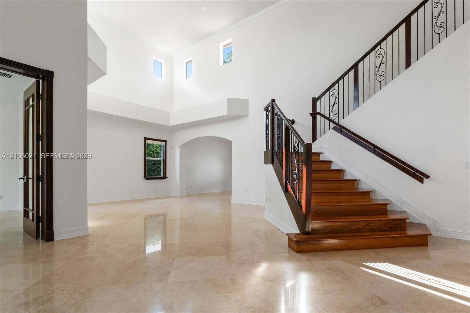 19510 S Coquina Way, Weston, FL 33332 Grand foyer featuring polished stone flooring, vaulted ceilings, and a wooden staircase with decorative metal balusters
