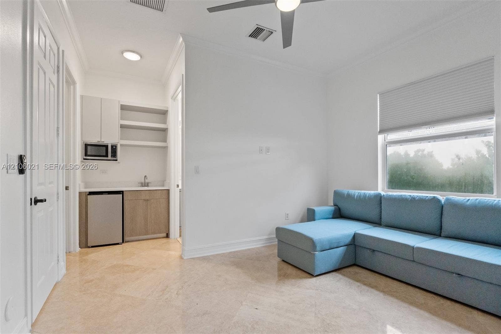 19510 S Coquina Way, Weston, FL 33332 Wet bar area featuring flat-panel cabinetry, light-finish countertops, an integrated microwave, and a sink