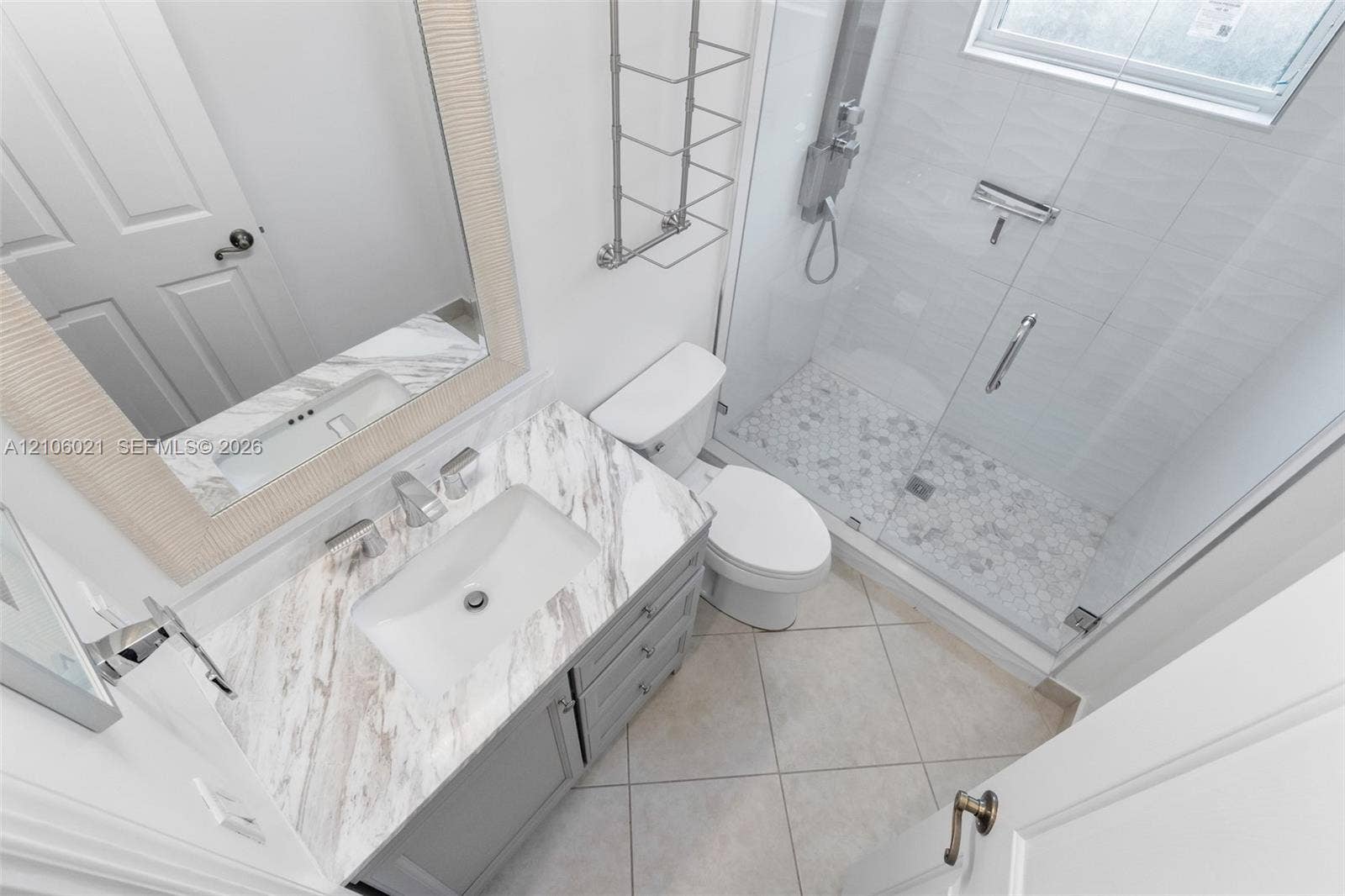 19510 S Coquina Way, Weston, FL 33332 Bathroom featuring a grey vanity with a white stone-patterned countertop, an integrated rectangular sink, a glass-enclosed shower with tiled flooring, and neutral tile flooring throughout