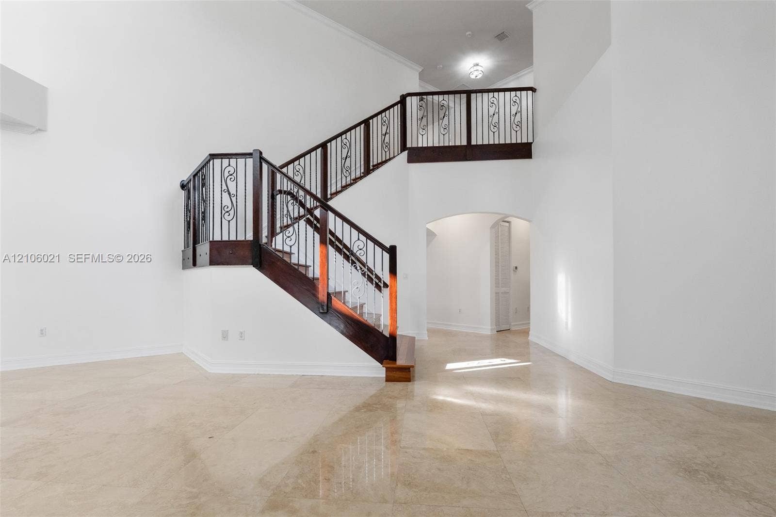 19510 S Coquina Way, Weston, FL 33332 Two-story staircase featuring wood-finish railings, ornate metal balusters, and stone-finish flooring