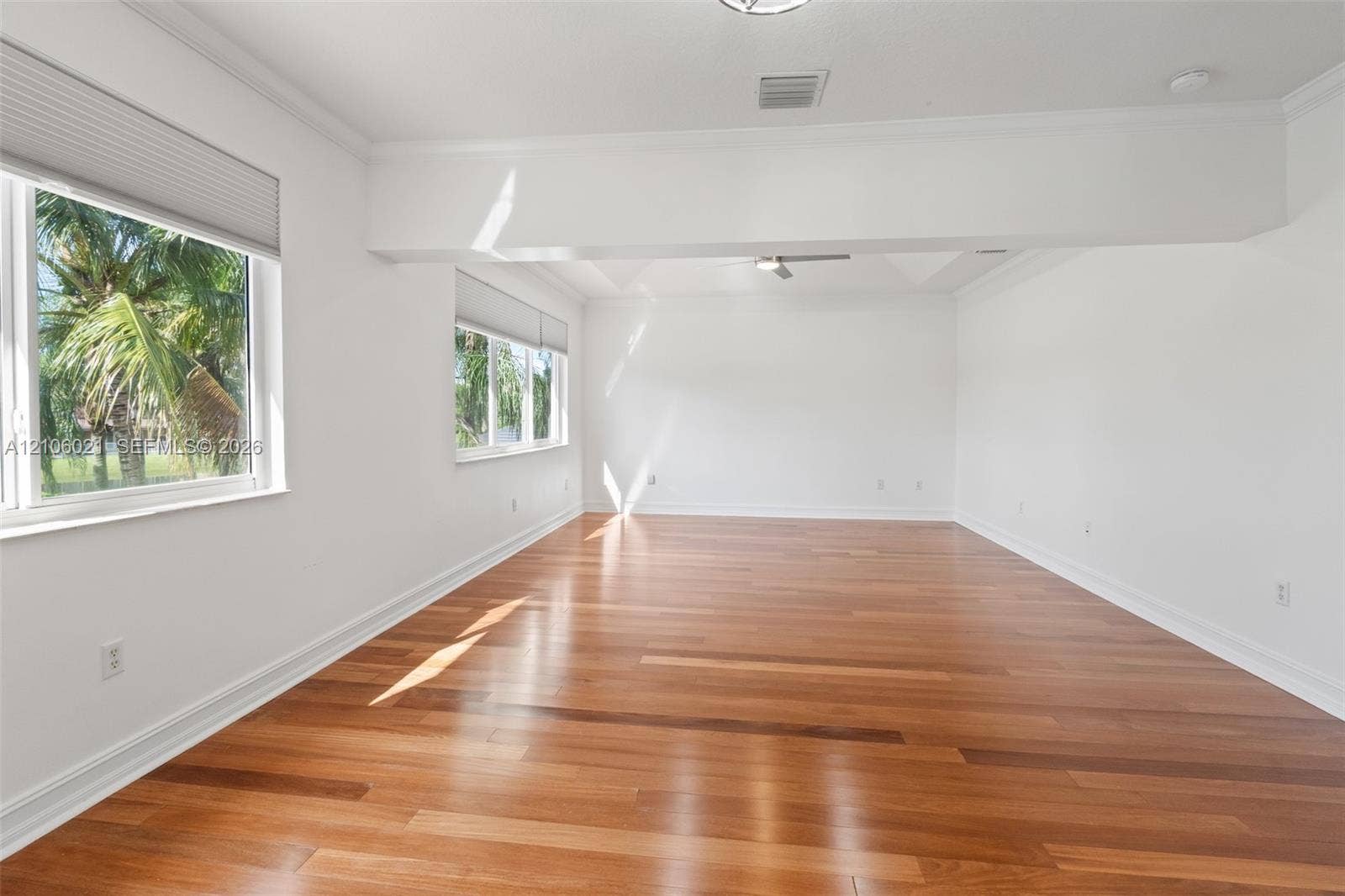 19510 S Coquina Way, Weston, FL 33332 Spacious interior featuring wood-finish flooring, tray ceiling, crown molding, and multiple windows with installed blinds
