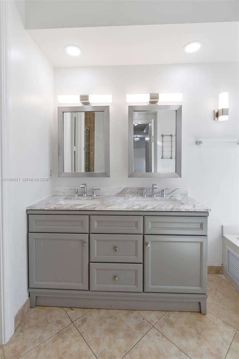 19510 S Coquina Way, Weston, FL 33332 Dual-sink vanity featuring grey cabinetry, stone-finish countertops, dual rectangular wall-mounted mirrors, and recessed overhead lighting