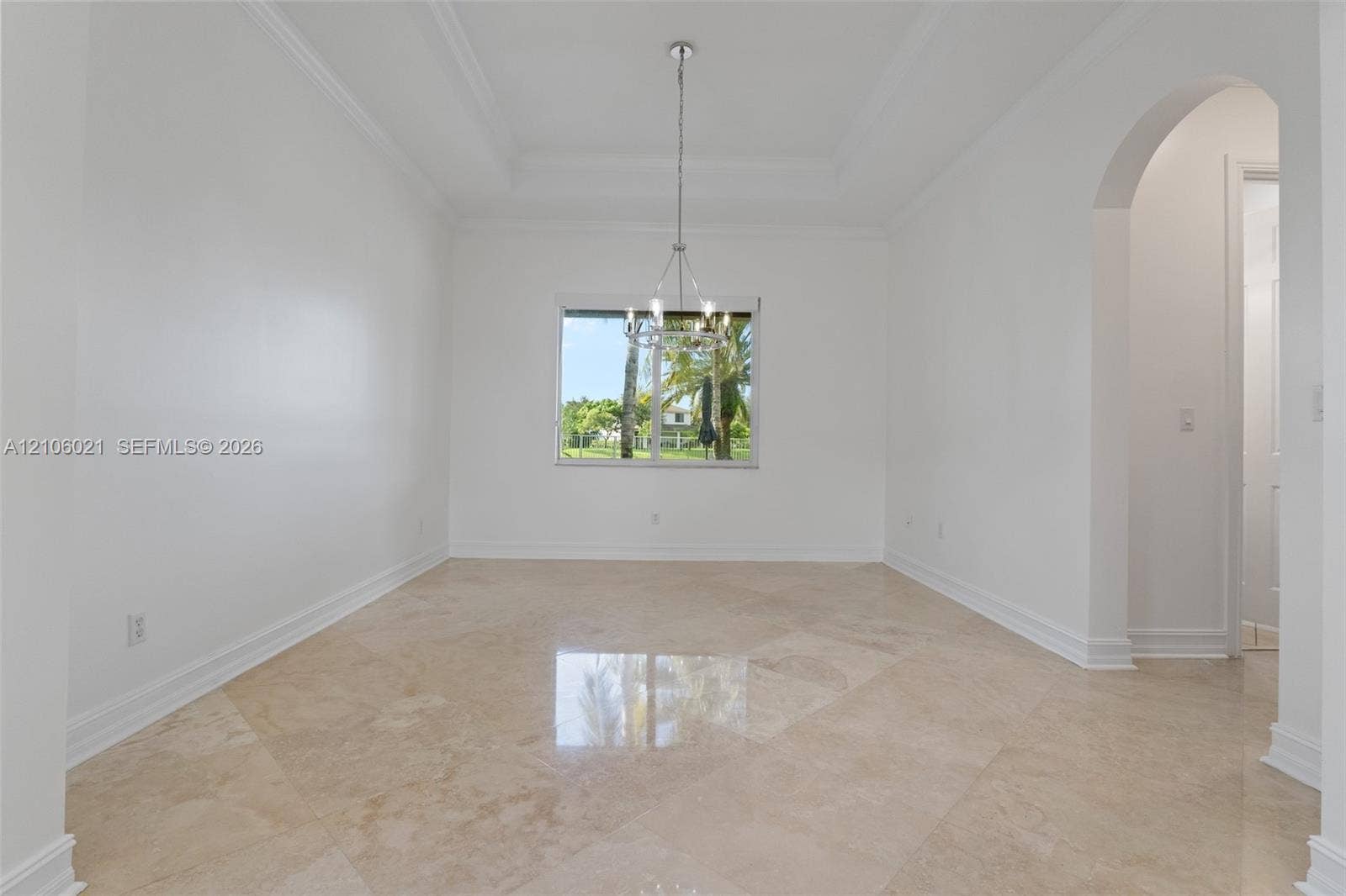 19510 S Coquina Way, Weston, FL 33332 Tray ceiling, stone tile flooring, multi-arm metal chandelier, and arched doorway