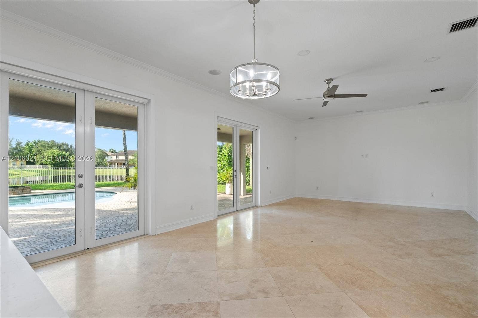 19510 S Coquina Way, Weston, FL 33332 Open-concept room featuring light-toned tile flooring, recessed ceiling lighting, a decorative drum pendant chandelier, and two sets of glass double doors providing exterior access