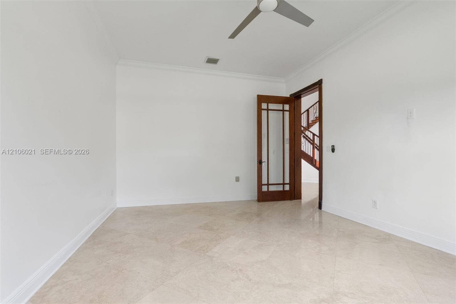 19510 S Coquina Way, Weston, FL 33332 Neutral-toned stone tile flooring, crown molding, multi-pane glass-inset wooden door, and a ceiling-mounted fan