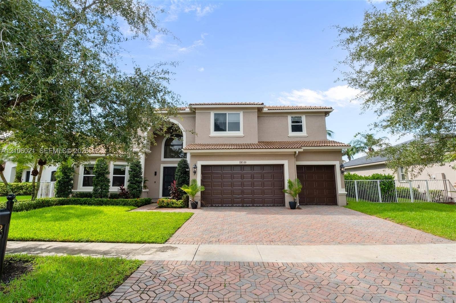 19510 S Coquina Way, Weston, FL 33332 Two-story exterior featuring a paver driveway, three-car garage, arched entryway, and tile roof