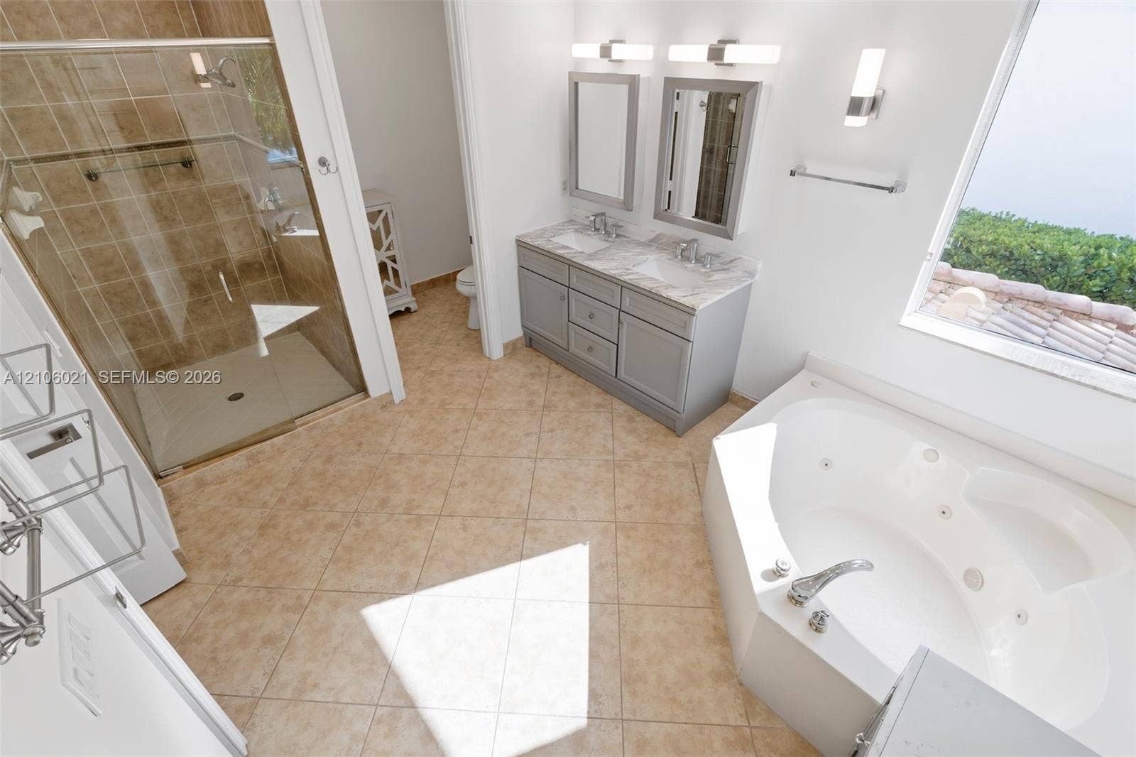 19510 S Coquina Way, Weston, FL 33332 Dual-sink vanity with stone-finish countertop, glass-enclosed shower with tile surround, and built-in jetted soaking tub