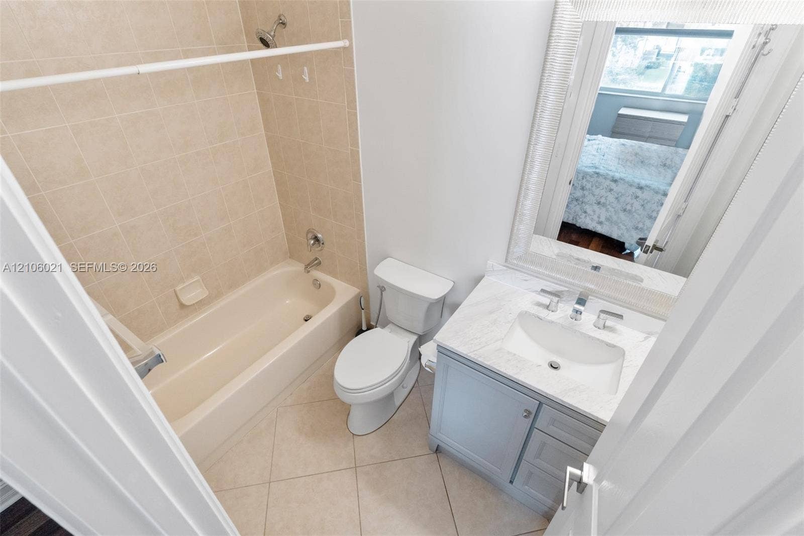 19510 S Coquina Way, Weston, FL 33332 Bathroom featuring a vanity with a stone-top counter, undermount sink, porcelain tile flooring, and a tub with tiled surround